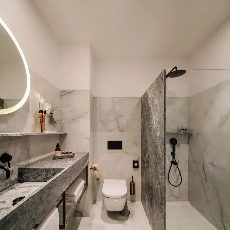 Luxuriöses Badezimmer mit Marmordetails und Regendusche
