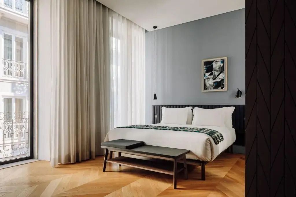 Modern eingerichtetes Hotelzimmer mit Doppelbett und Holzboden