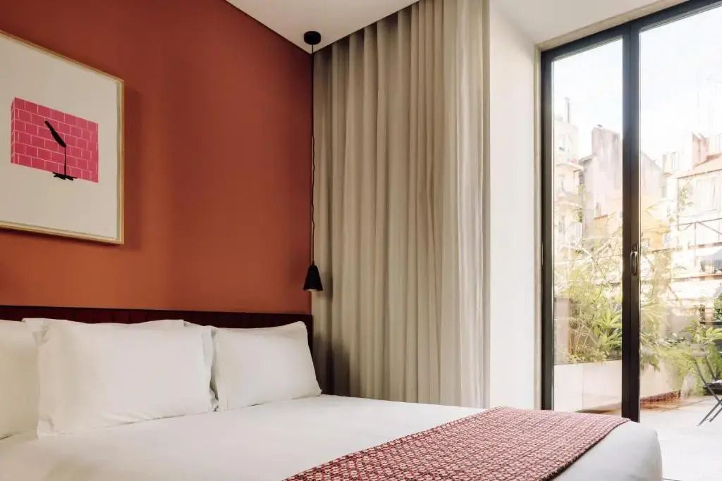 Geräumiges Zimmer mit großem Fenster und Ausblick auf eine Terrasse