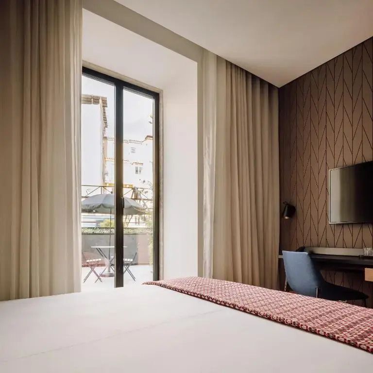 Modernes Hotelzimmer mit bodentiefem Fenster und Zugang zur Terrasse