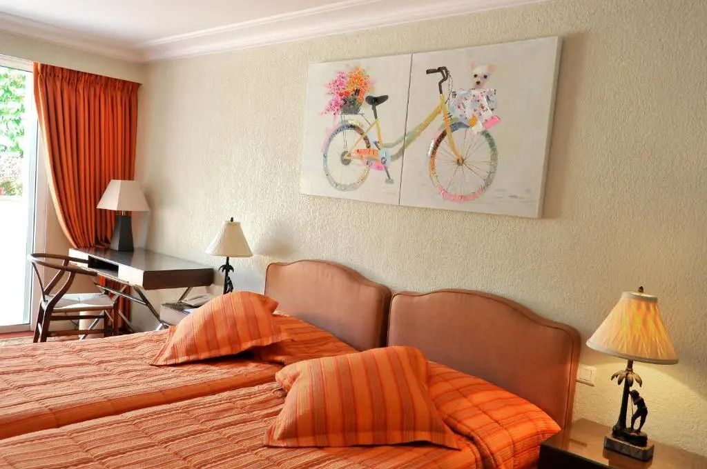 Schlafzimmer mit zwei Betten und dekorativem Bild an der Wand.