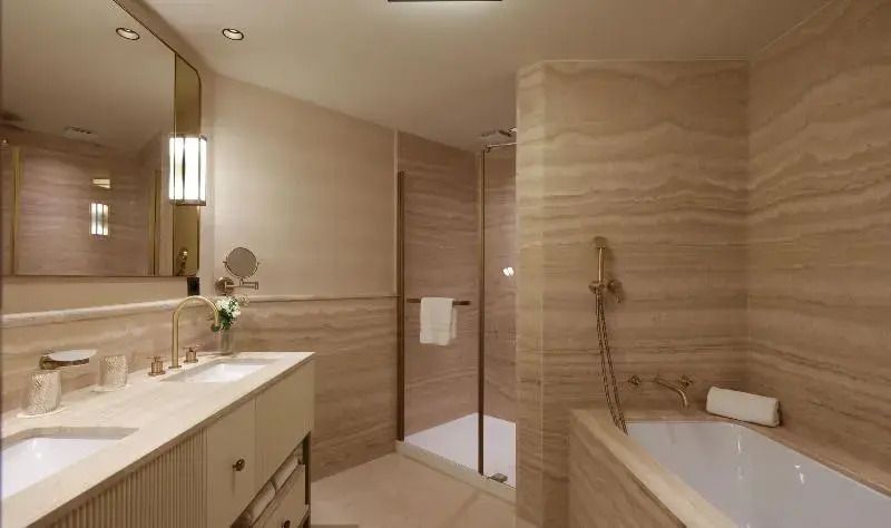Luxuriöses Badezimmer in Marmoroptik mit Badewanne und Dusche in der Klassisch Junior-Suite