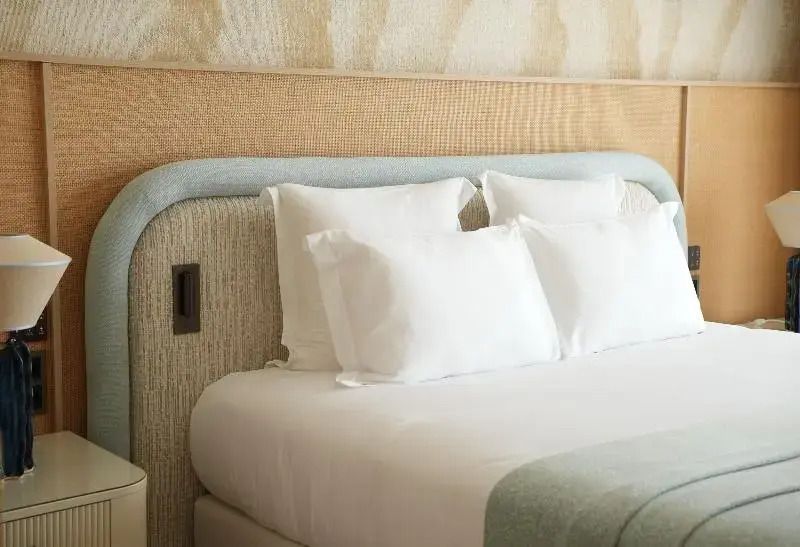 Gemütliches Doppelbett mit luxuriöser Bettwäsche und stilvollem Kopfteil.