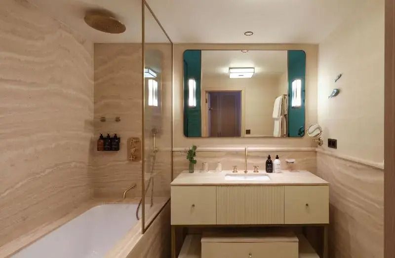 Modernes Badezimmer mit Badewanne, großem Spiegel und eleganter Beleuchtung.