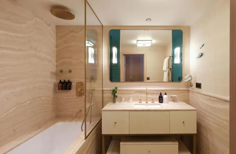 Luxuriöses Badezimmer mit eleganter Marmorverarbeitung und großer Spiegel