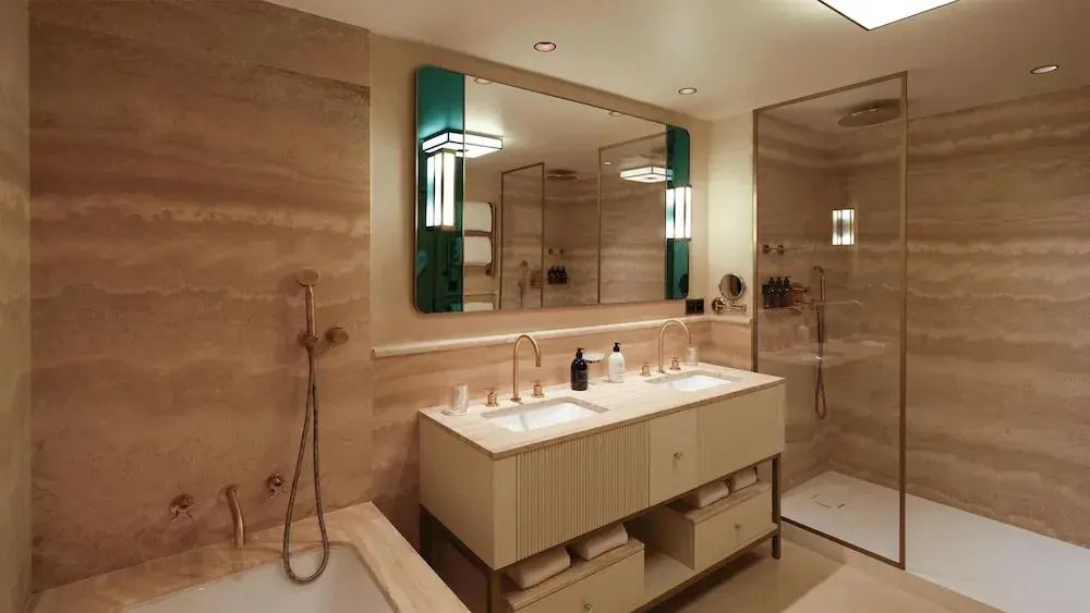 Elegantes Badezimmer der Suite mit Doppelwaschbecken und moderner Beleuchtung.