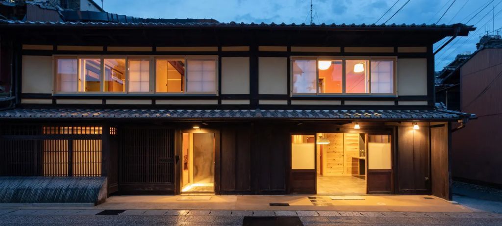 Traditionelles japanisches Haus im Abendlicht mit Holzelementen und beleuchteten Fenstern