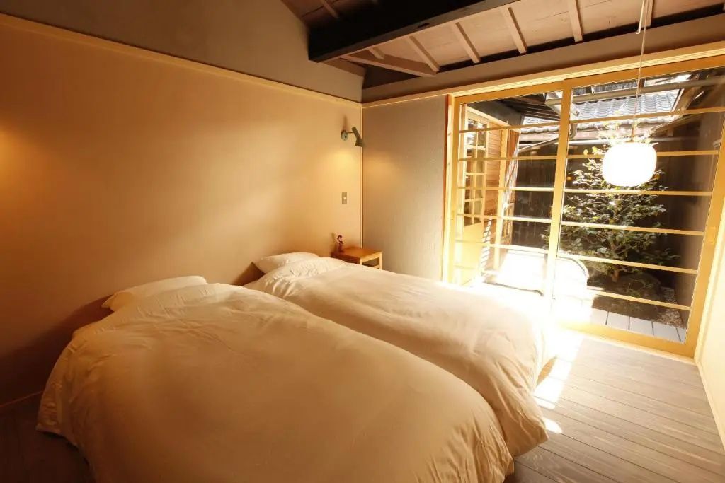 Helles Schlafzimmer mit zwei Einzelbetten und einem großen Fenster