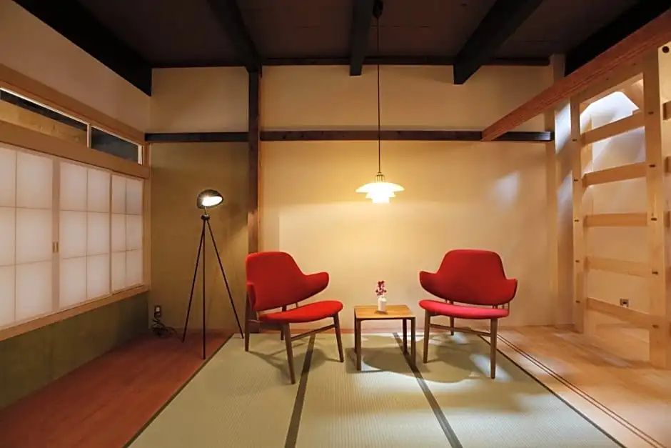 Gemütliche Sitzecke mit roten Sesseln und japanischen Designelementen