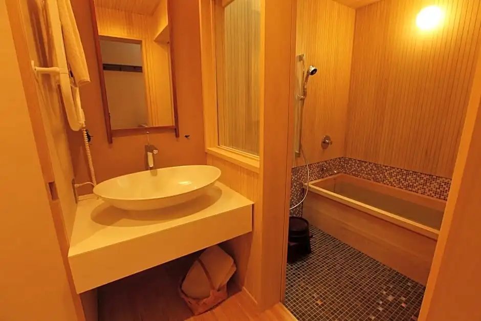 Modernes Badezimmer mit Waschtisch und Badewanne in heller Holzoptik