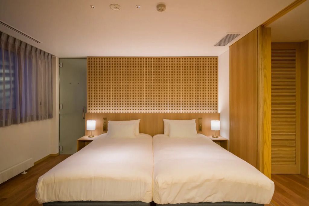 Moderne Betten mit Holzverkleidung und sanfter Beleuchtung im Hotelzimmer