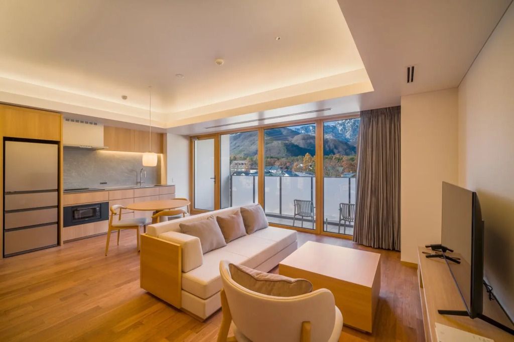 Helles Wohnzimmer mit Sofa und Bergblick durch große Fenster