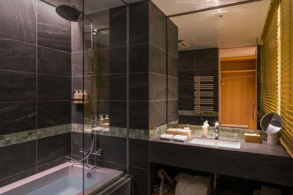 Luxuriöses Badezimmer mit dunklen Fliesen und Badewanne