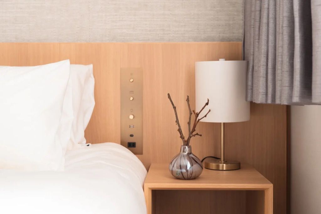 Nachttisch mit Lampe und Blumendekoration im Standard Doppelzimmer