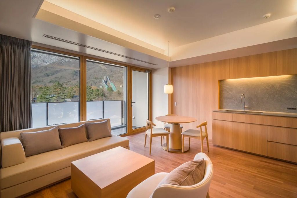 Wohnbereich mit Sitzecke und Blick auf die Berge im Hotelzimmer