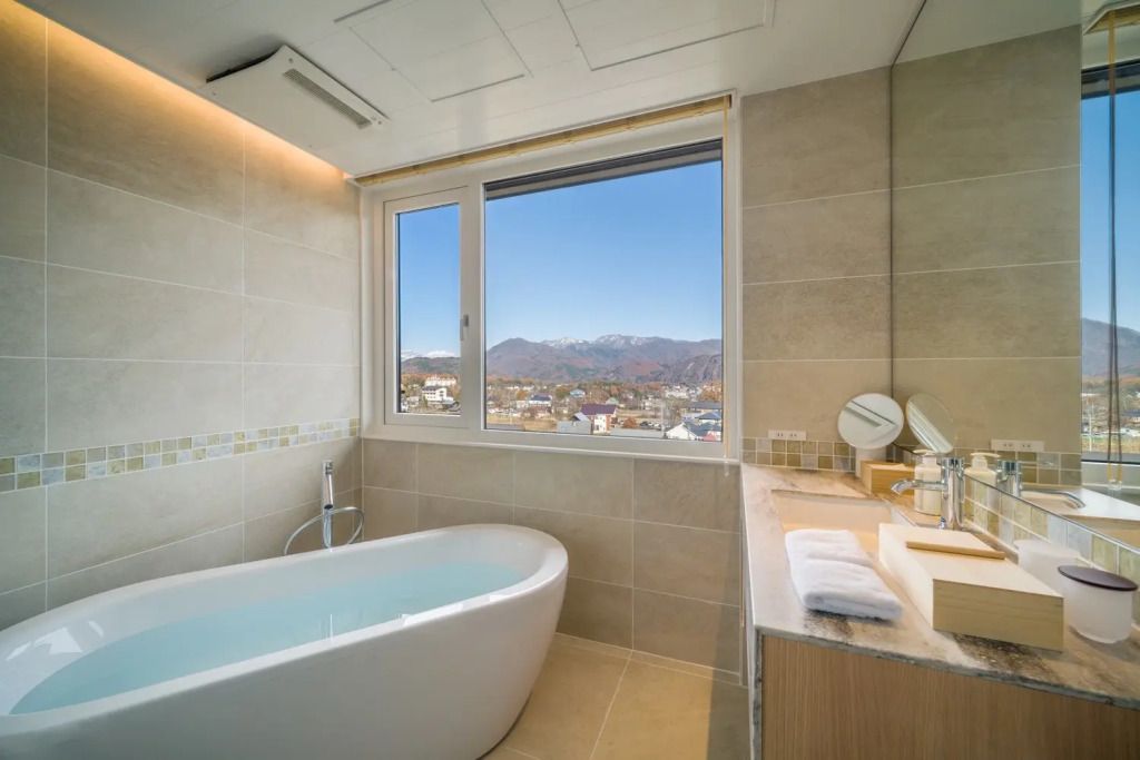 Badezimmer mit freistehender Badewanne und Bergblick