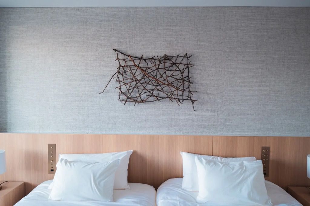 Kunstvoll dekorierte Wand über zwei Einzelbetten in einem modern eingerichteten Zimmer