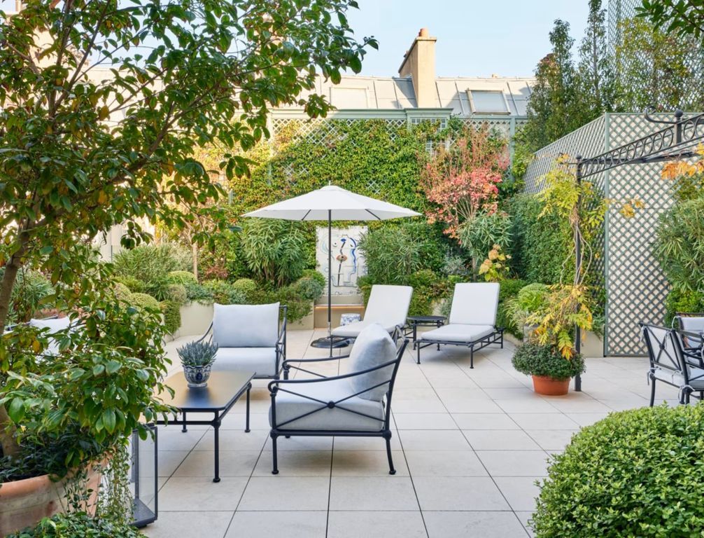 Grüne Terrasse mit gemütlichen Sitzgelegenheiten und reicher Bepflanzung