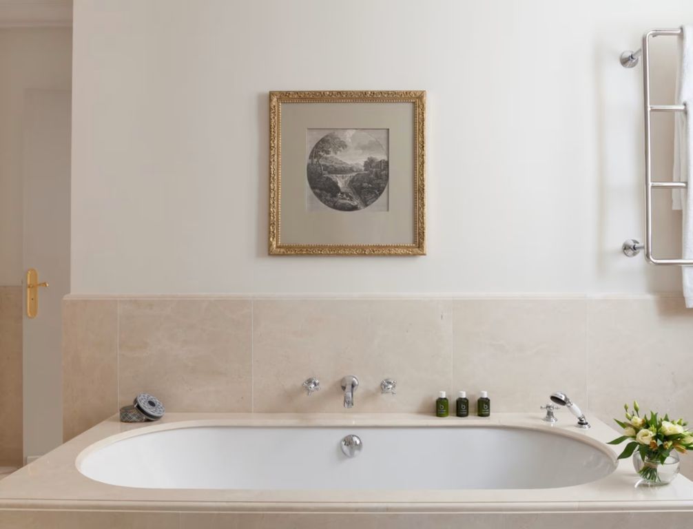 Freistehende Badewanne in der Deluxe Suite mit stilvoller Wandkunst