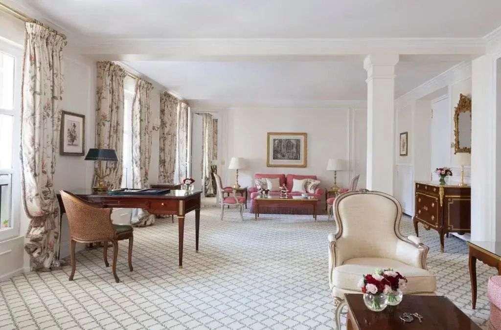 Großzügige Suite mit Schreibtisch, Sesseln und Fensterblick im Hotel Le Bristol Paris.