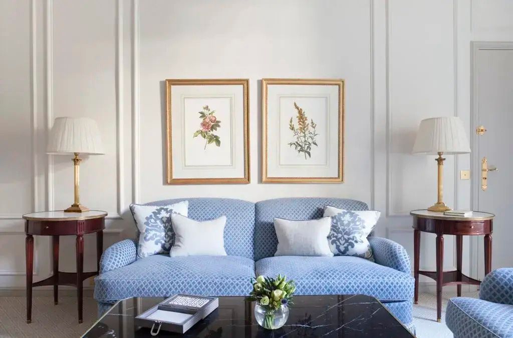 Stilvolles Wohnzimmer mit blauer Couch und Kunst an der Wand in der Magnolia Suite