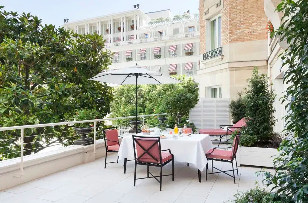 Private Terrasse der Suite mit Tisch und Stühlen umgeben von üppigem Grün