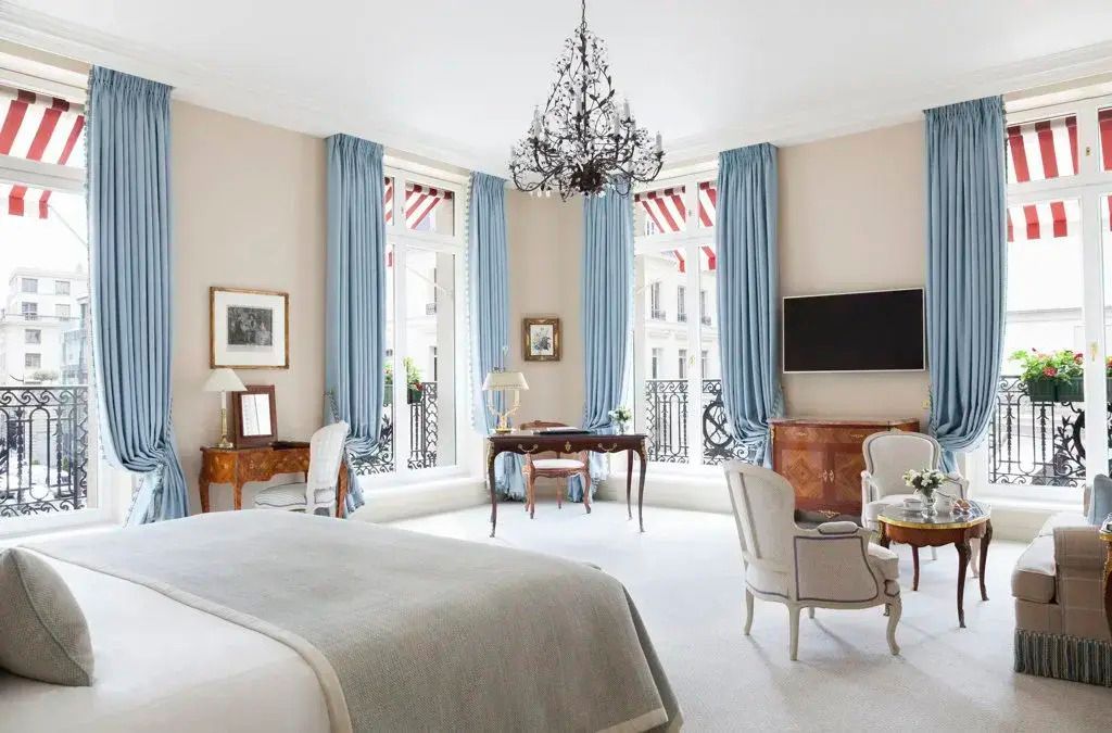 Elegante Suite mit klassischer Einrichtung, großem Bett und Kronleuchter, helle Farben