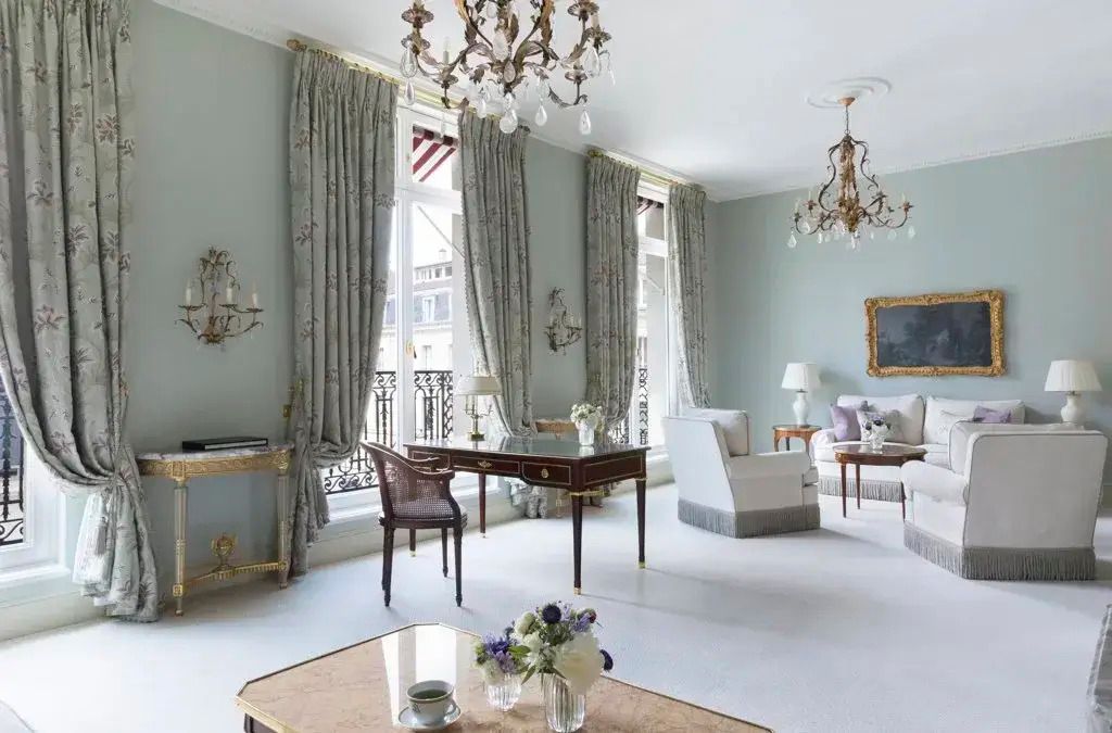 Heller Wohnbereich mit großen Fenstern, eleganter Einrichtung und Kronleuchtern