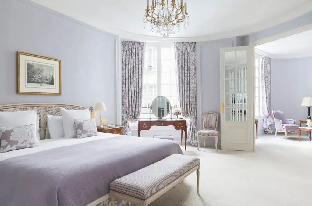 Elegantes Hotelzimmer mit großem Bett, hellem Dekor und Kronleuchter