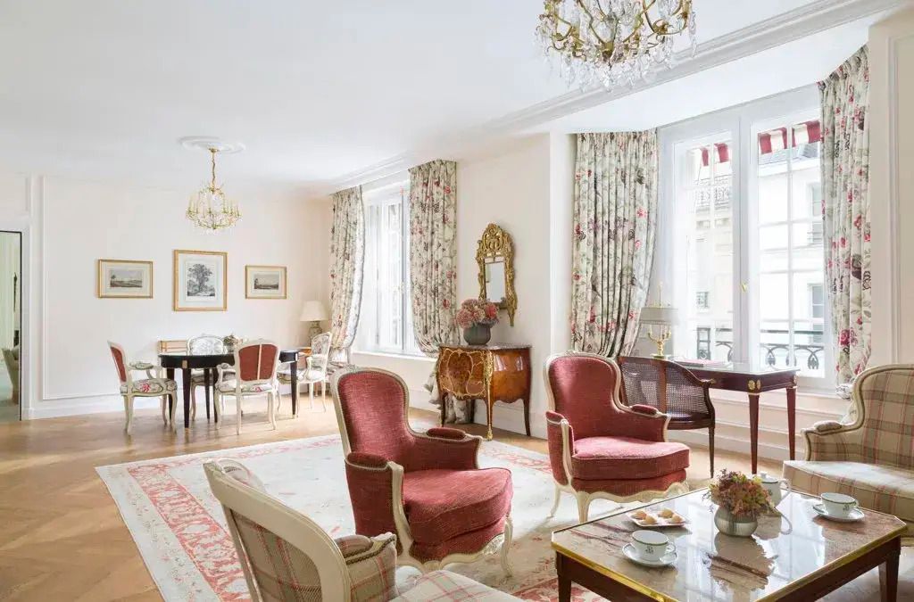 Luxuriös eingerichtete Zimmer im Hotel Le Bristol Paris mit rosa Sesseln und Kronleuchtern.