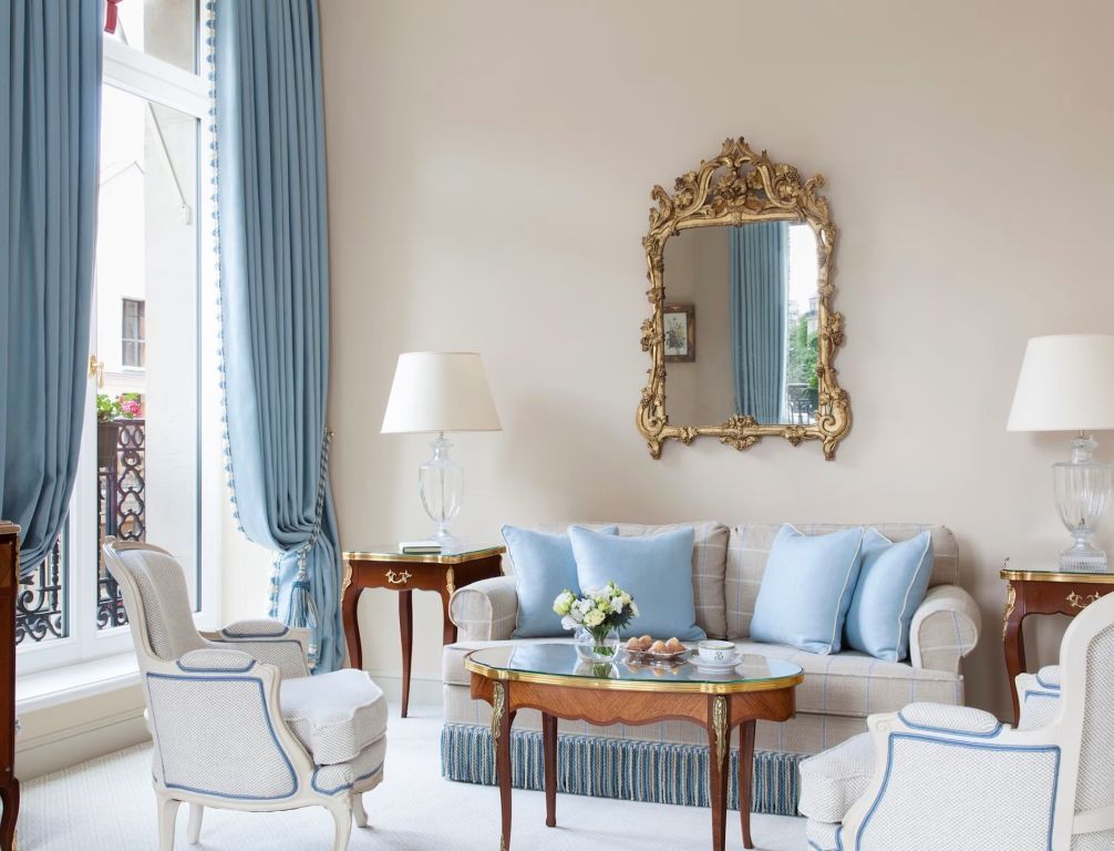 Eleganter Sitzbereich mit Spiegel und blauen Kissen in der Suite.