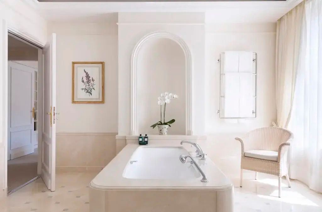 Elegantes Badezimmer mit freistehender Badewanne und Orchidee.