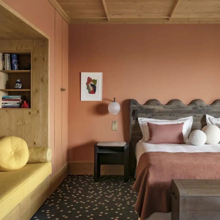 Gemütliches Hotelzimmer mit Holzmöbeln, Doppelbett und Leseecke