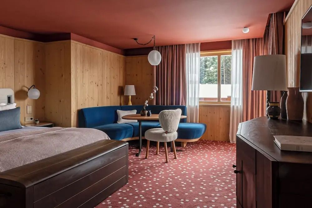 Großzügiges Zimmer mit moderner Sitzecke und Holzwänden