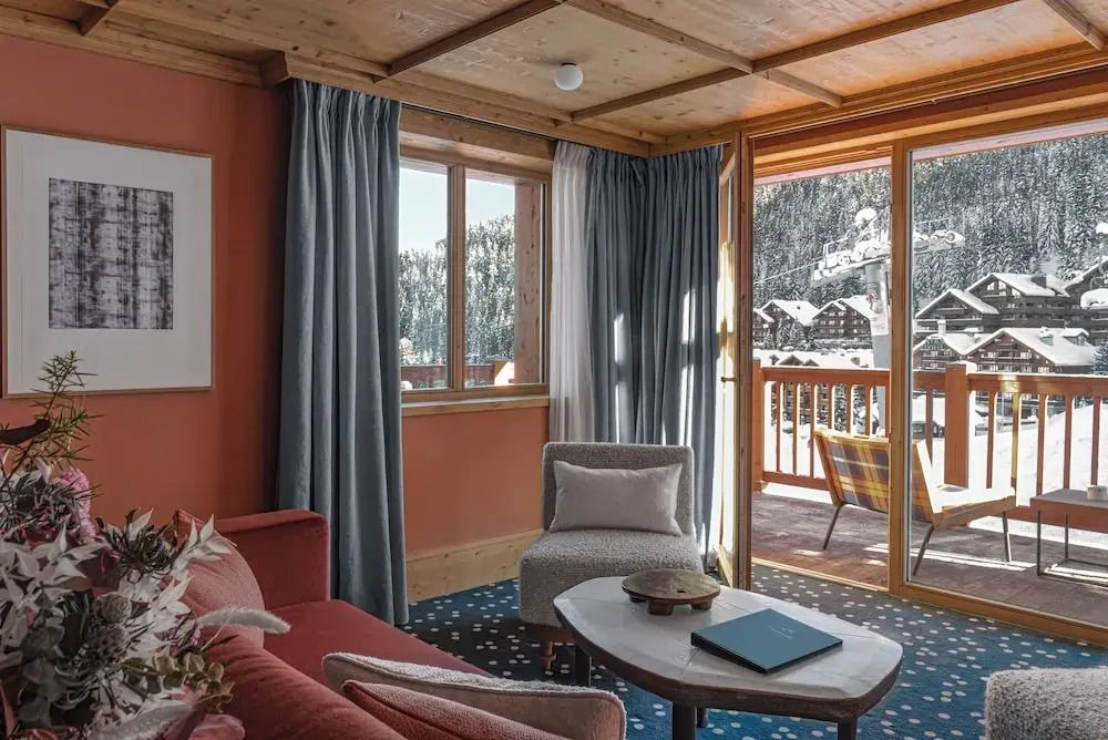 Gemütliches Wohnzimmer mit großen Fenstern und Bergblick