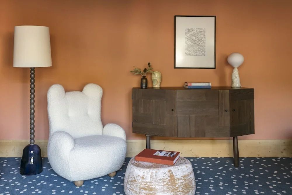 Gemütlicher Lounge-Bereich mit Sessel, Holzschrank und Kunstdekor