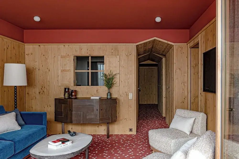 Wohnbereich der Suite mit Holzwänden und eleganter Einrichtung