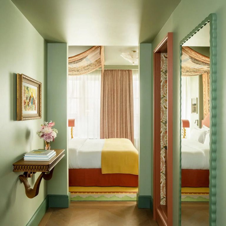 Einladender Durchgang mit Spiegel, Kunst und Blick auf das gemütliche Bett