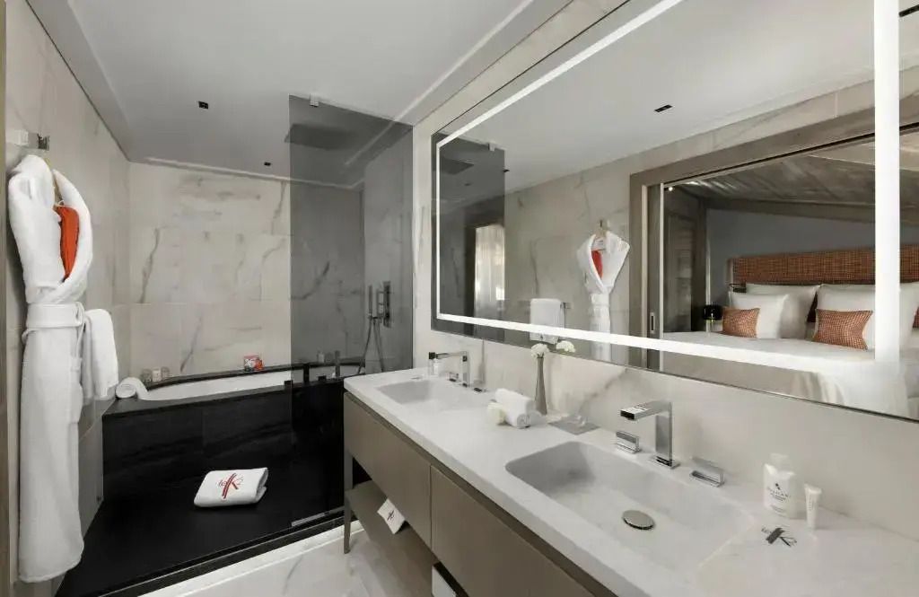 Modernes Badezimmer mit Doppelwaschbecken und geräumiger Dusche in der Junior-Suite.