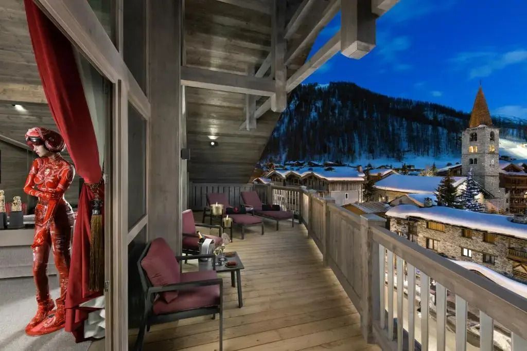 Private Terrasse einer Suite mit Sitzgelegenheiten und Bergblick bei Nacht