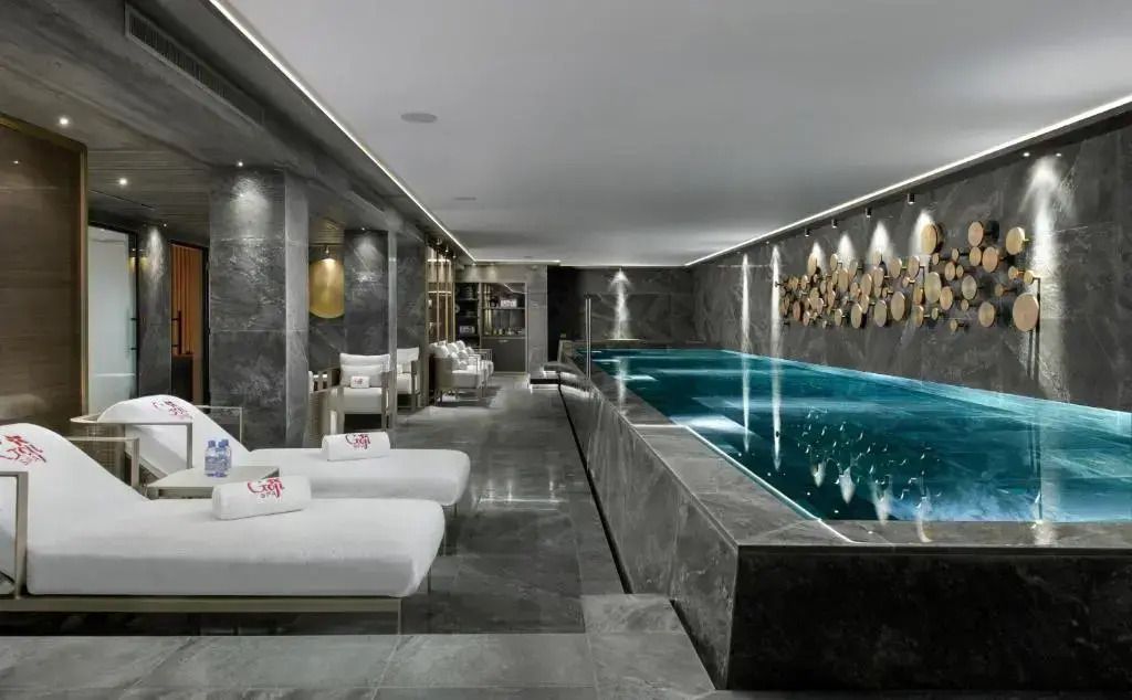 Eleganter Indoor-Poolbereich mit Liegen und entspannendem Ambiente