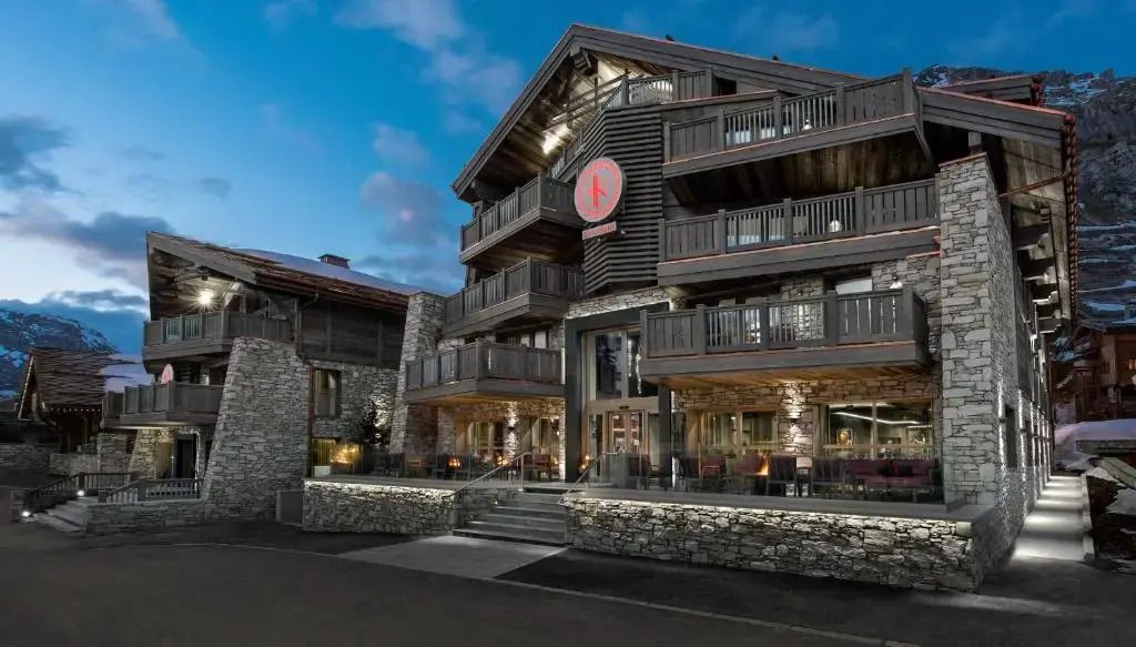 Prächtige Hotelaußenansicht aus Stein und Holz mit beleuchteter Fassade