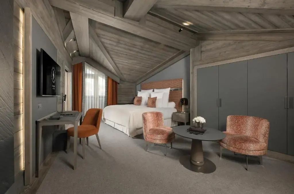 Geräumiges Zimmer mit Holzdecke, bequemen Stühlen und moderner Einrichtung.