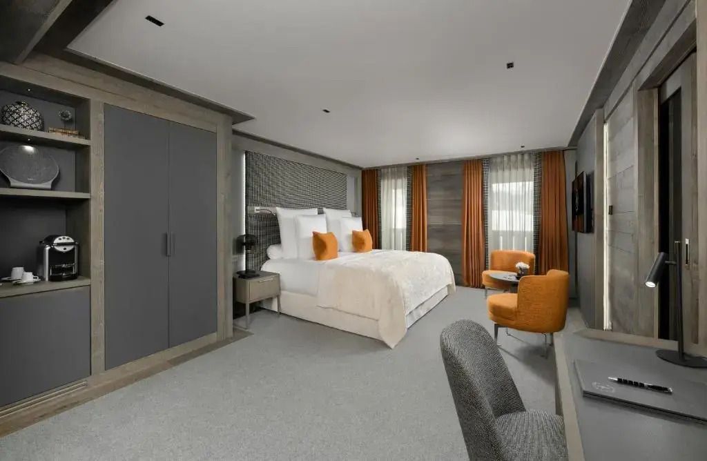 Modernes Doppelzimmer mit hellem Design, gemütlichen Sesseln und großzügigem Raum.