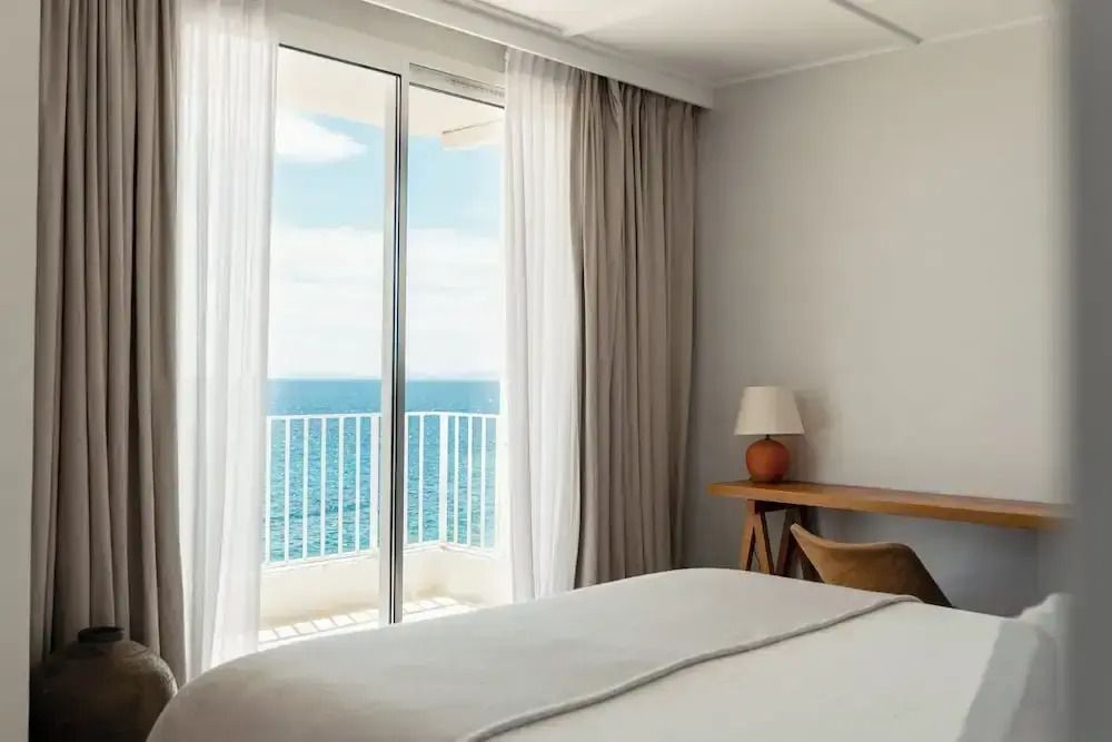 Zimmer mit großem Fenster und Meerblick auf den blauen Horizont