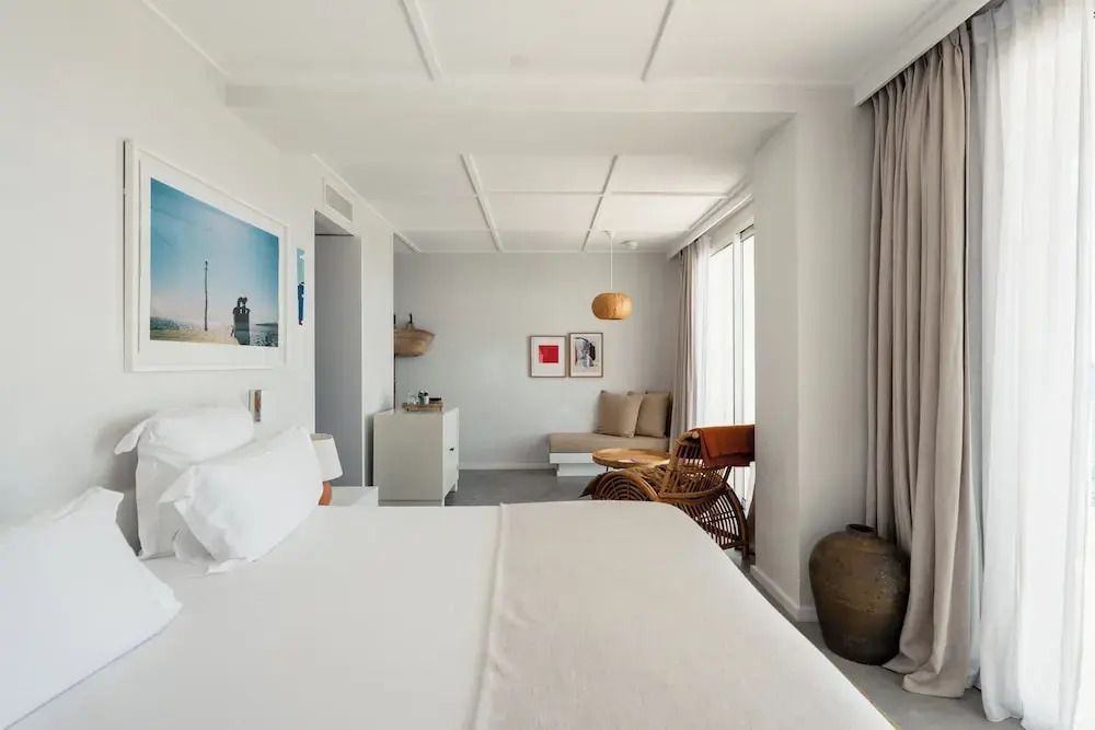 Offener Bereich der Junior-Suite mit Bett, Sitzbereich und Kunst an der Wand