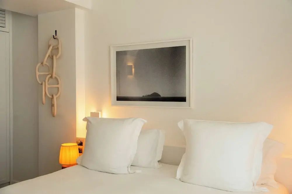 Nahaufnahme eines Bettes mit eleganter Bettwäsche und künstlerischem Bild an der Wand