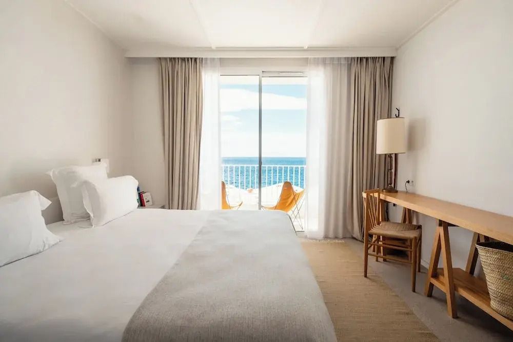 Helles Zimmer mit großem Bett und Meerblick durch Fenster