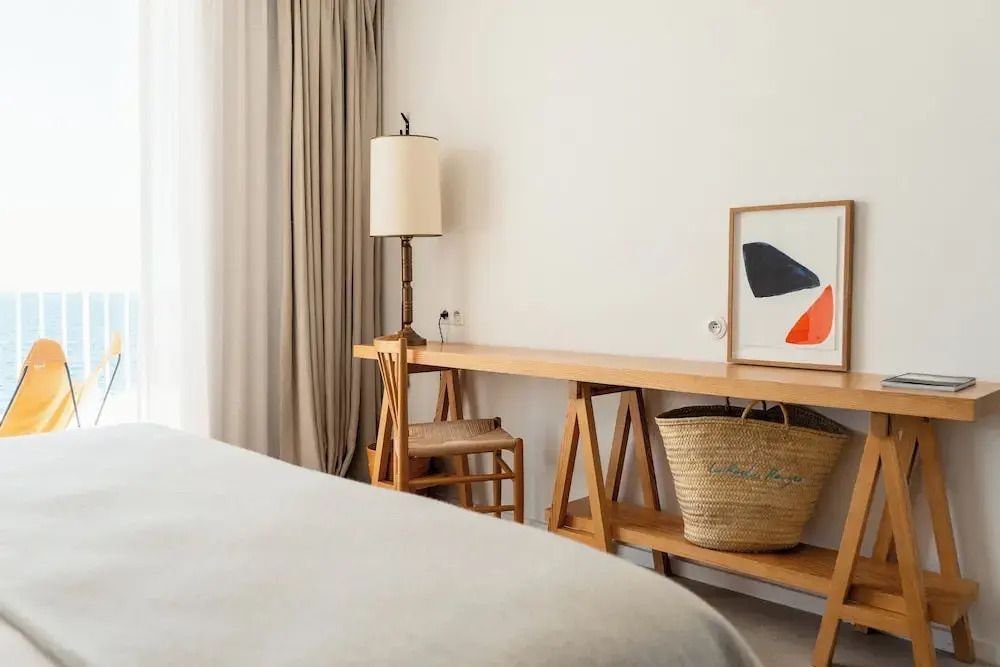 Schreibtisch im Zimmer mit Lampe und Kunstwerk an der Wand