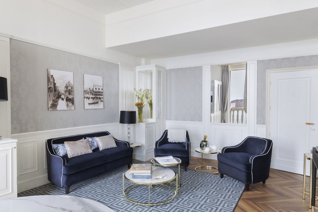 Wohnbereich einer Suite mit luxuriösen Möbeln und Kunstwerken an den Wänden